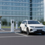 коммерческая зарядная станция с двумя розетками Type2 мощностью 2х22 кВт GNLT AC CK 44kW T2 заряжает электромобиль на парковке офиса